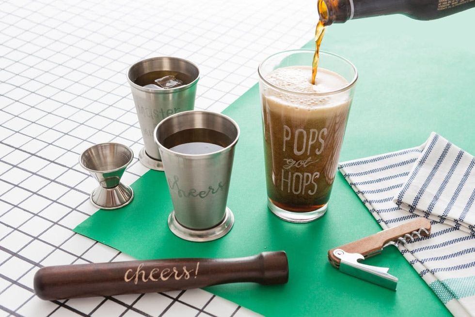 Bar tools and glasses on a grid surface; "Pops got hops" pint being filled with beer.
