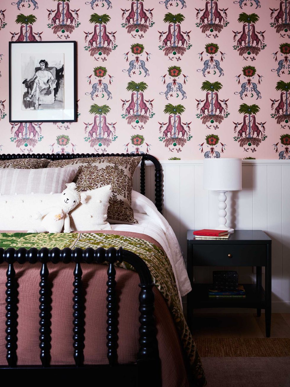 Bedroom with patterned wallpaper, framed artwork, and a bed with plush bedding.