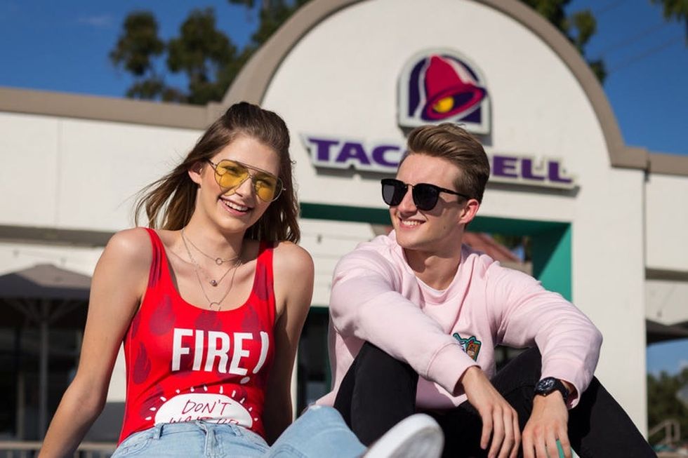 Beginning today, fans of both brands can submit photos or videos on social using #F21xTacoBell to be featured in design details alongside models debuting the collection. Select content submitted will be incorporated on the runway on October 10. Beloved Taco Bell super fans Brittany Creech and Andrew McBurnie first defined the title super fan with iconic Taco Bell senior portraits and will model the collection along with a diverse set of fans and influencers. (PRNewsfoto/Taco Bell Corp.)