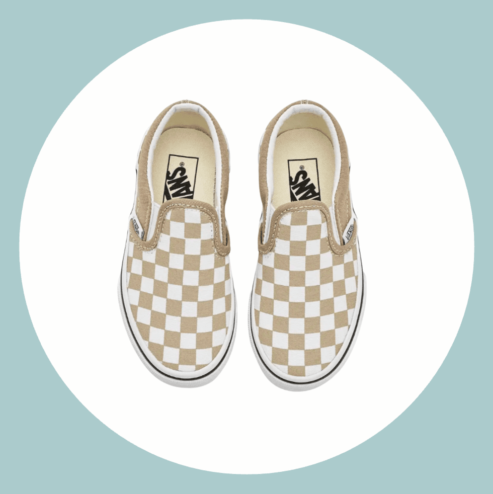 Beige and white checkered slip-on shoes on a circular background.