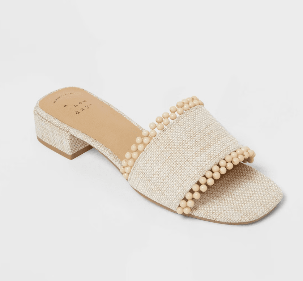 Beige slip-on sandal with beaded straps and low heel.