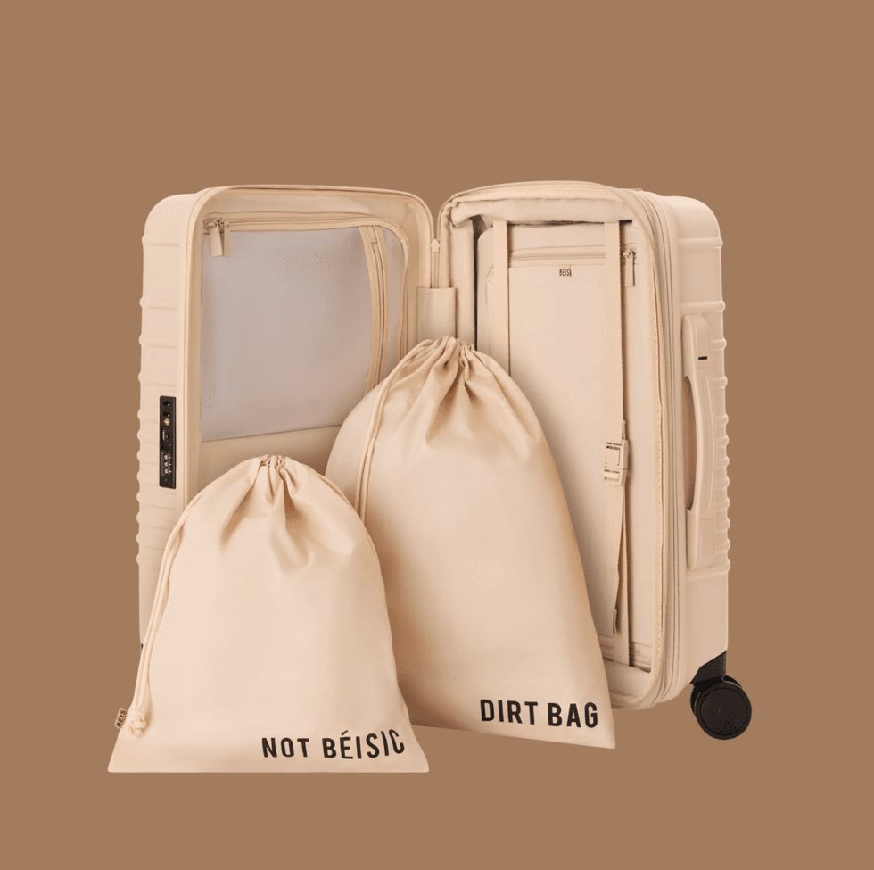 Beige suitcase open, with two labeled drawstring bags inside.