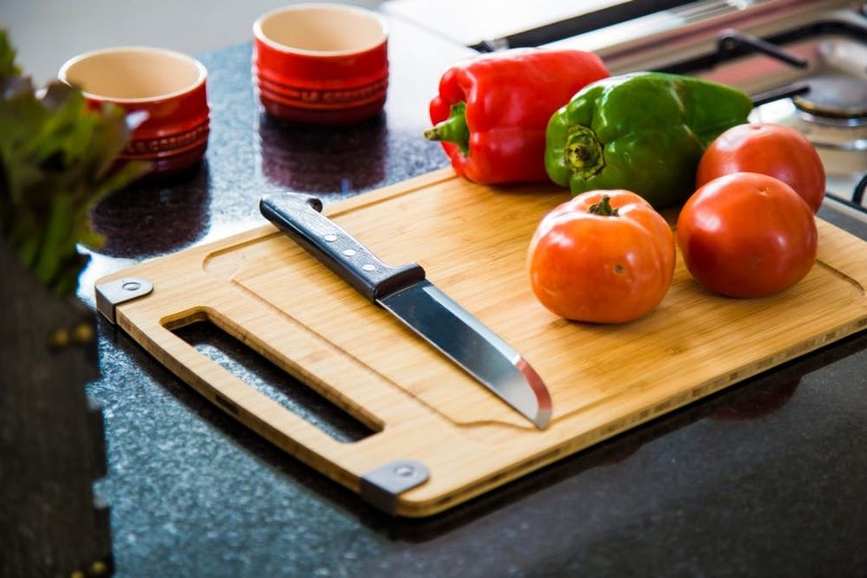 Bell peppers and tomatoes rest on a cutting board