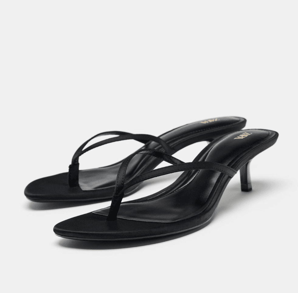 Black strappy high-heeled sandals on a white background.