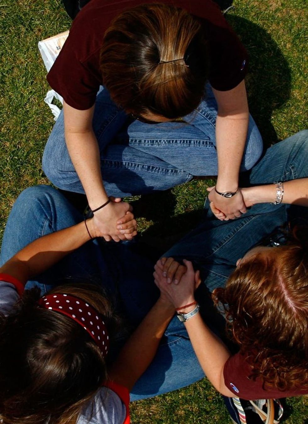 BLACKSBURG, VA - APRIL 18: Virginia Tech students, faculty and alumni pray during an interfaith service sponsored by the Virginia Tech Campus Ministry Association on the drill field of the university's campus April 18, 2007 in Blacksburg, Virginia. The university's community continues to mourn the victims of the rampage two days after more 33 people were killed when a gunman opened fire on the campus in the deadliest school shooting in American history. (Photo by Win McNamee/Getty Images)