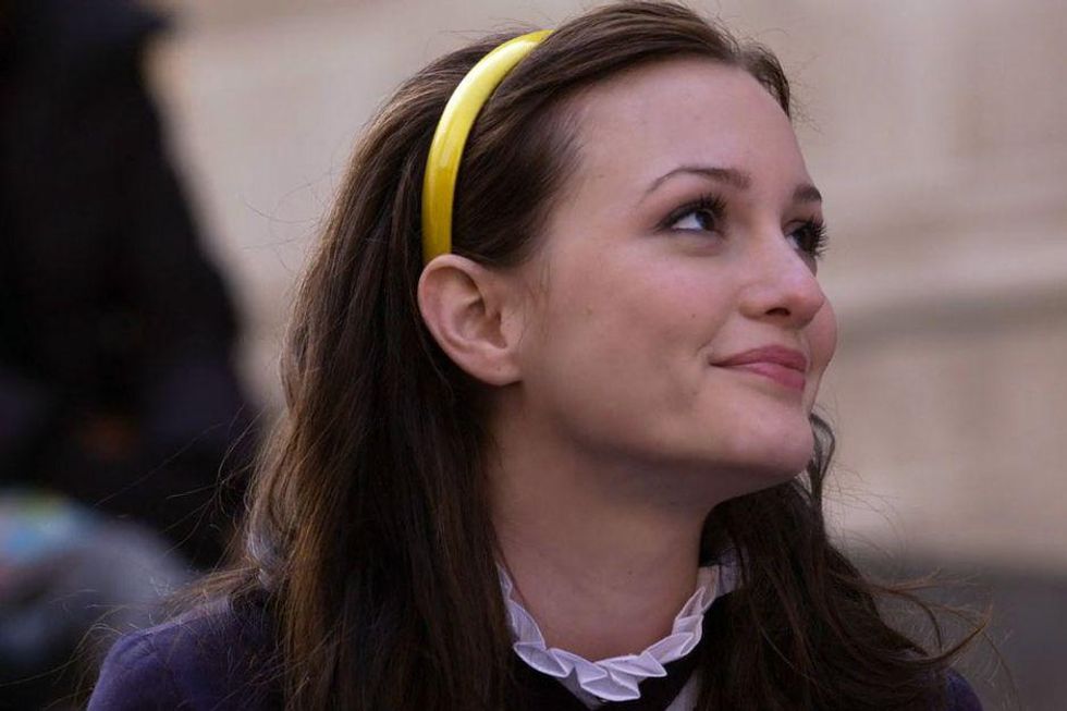 blair waldorf wears a yellow headband while sitting on the met steps