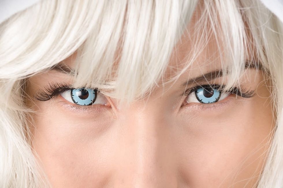 Blonde woman wearing bright blue colored contacts.