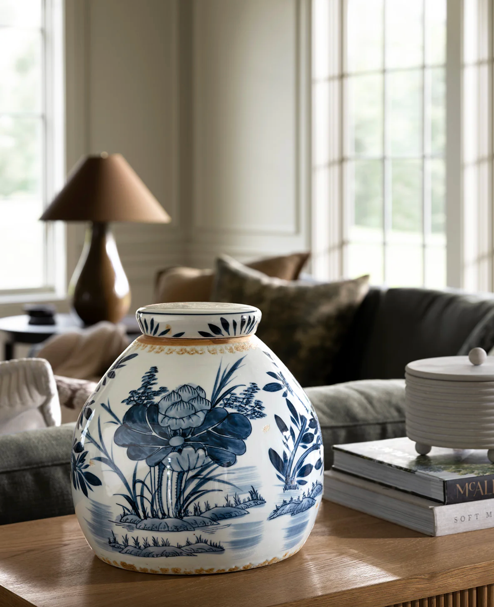 Blue and white floral vase on a wooden table in a cozy living room.