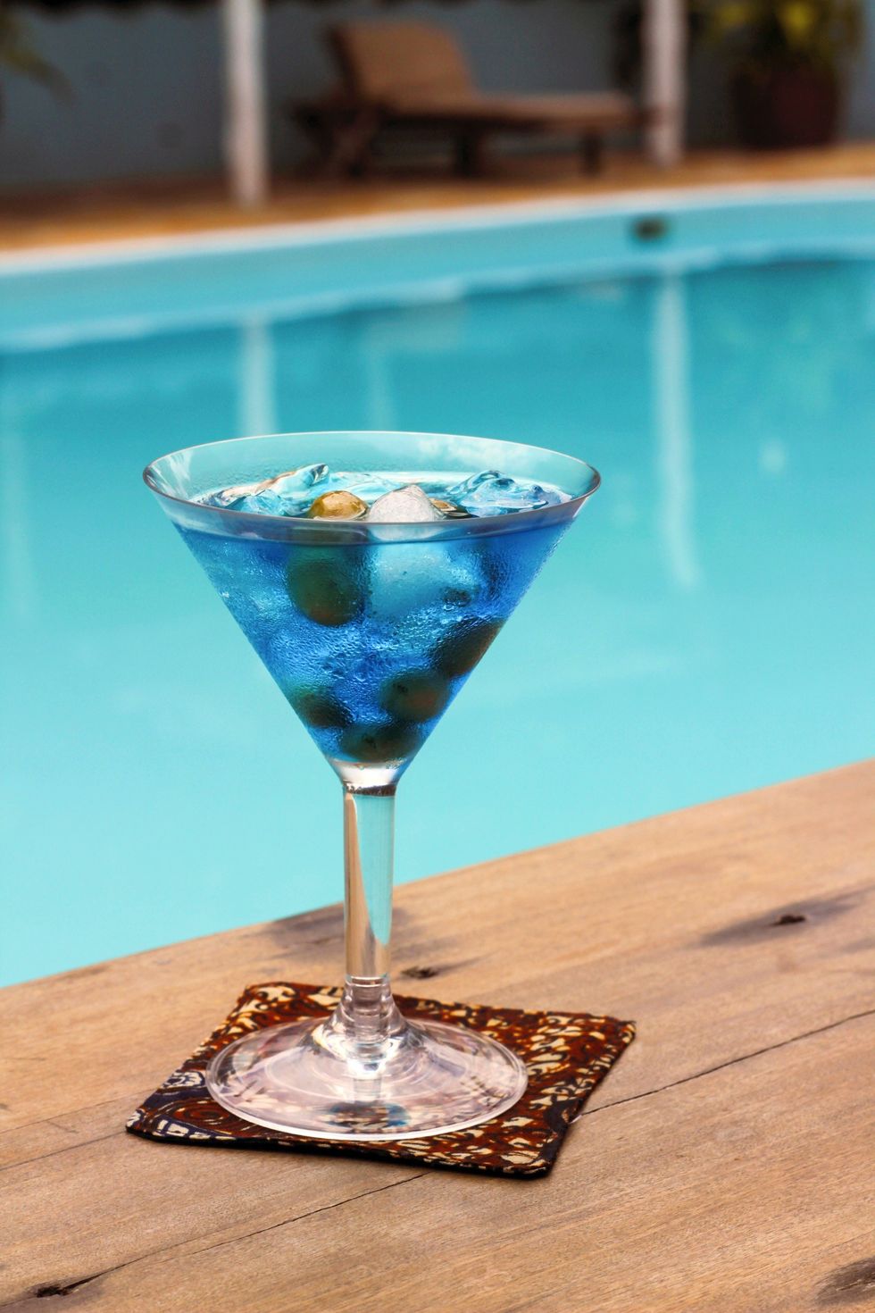blue cocktail sitting by a pool