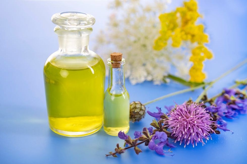 bottles of essential oils surrounded by flowers.