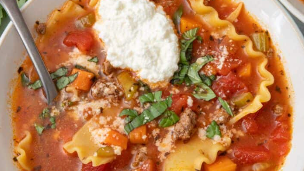Bowl of lasagna soup with ricotta, basil, and vegetables.