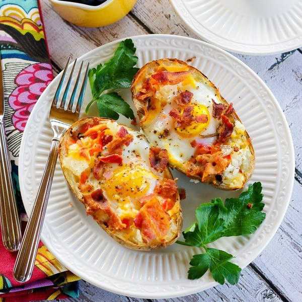 Breakfast with stuffed potatoes, berries, and a cup of coffee on a rustic table.