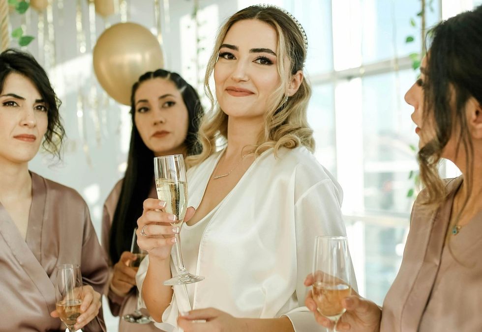 bride with her bridesmaids drinking champagne at her bachelorette party