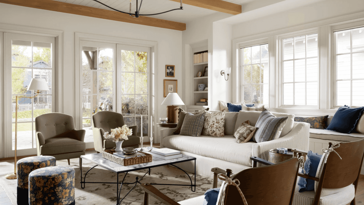 Bright living room with white walls, plush seating, and large windows.