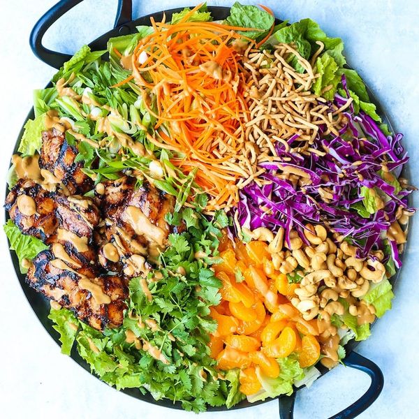 Bright rainbow colored salad with grilled chicken on a dark plate set on a white countertop is just one of 35 easy lunch ideas and recipes.