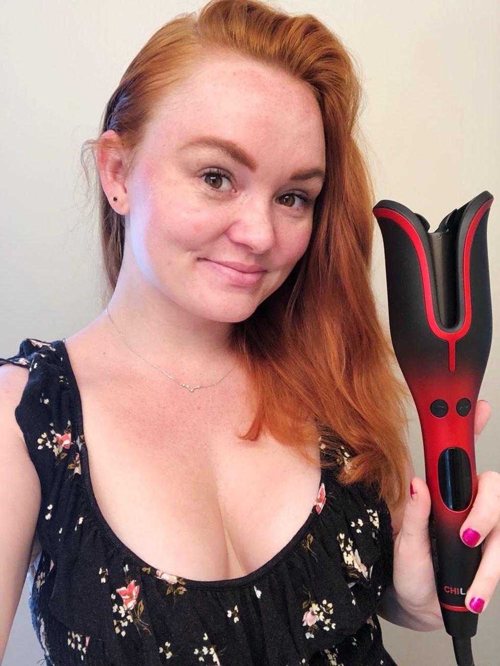 Brit + Co's beauty editor, Rebecca Norris, holding the CHI Lava Spin N Curl pre-review.