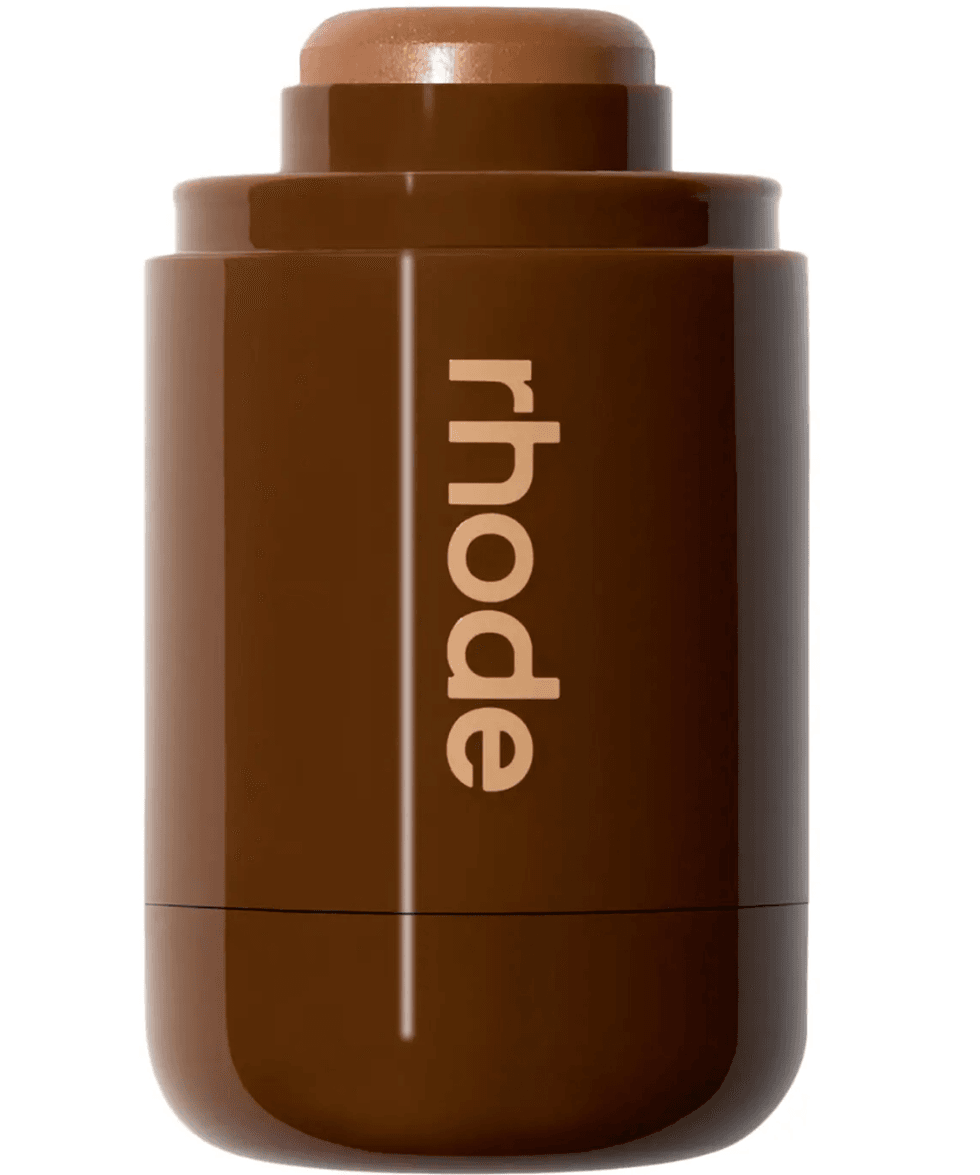 Brown cosmetics stick with "rhode" text on the side.