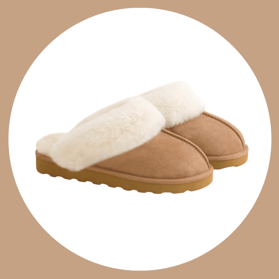 Brown slippers with white fur lining on a beige background.