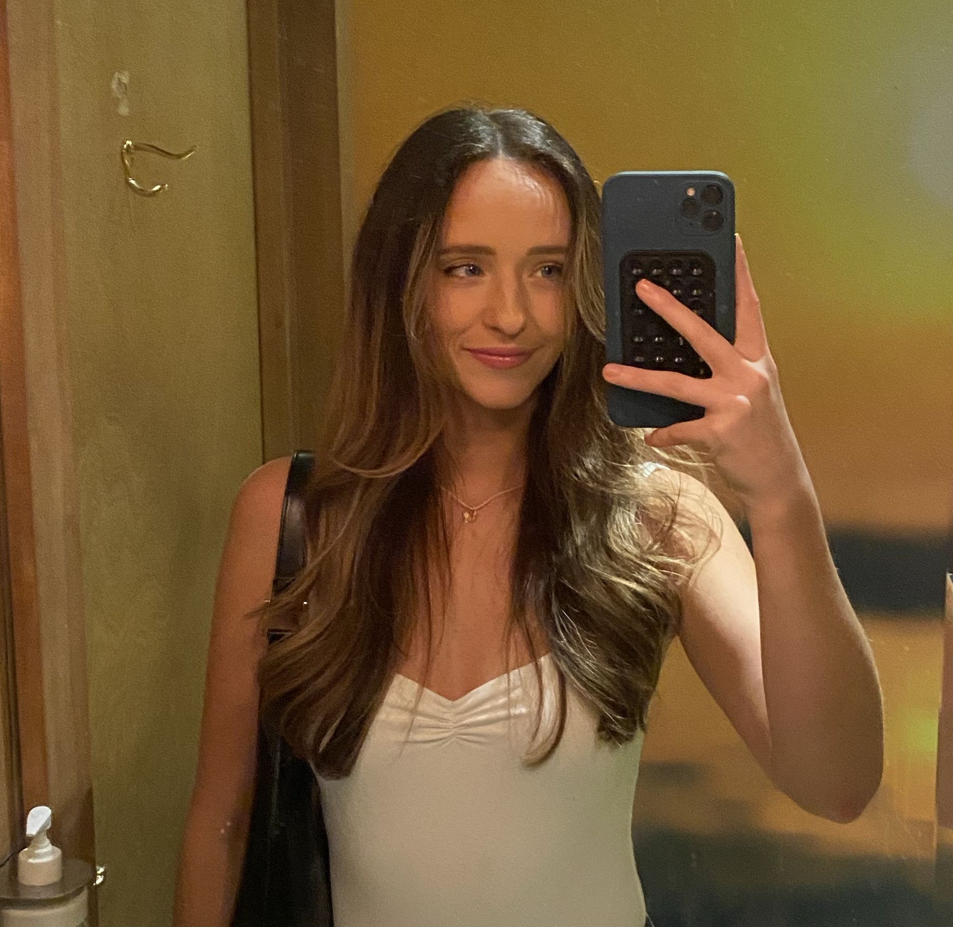 brunette woman taking a mirror selfie