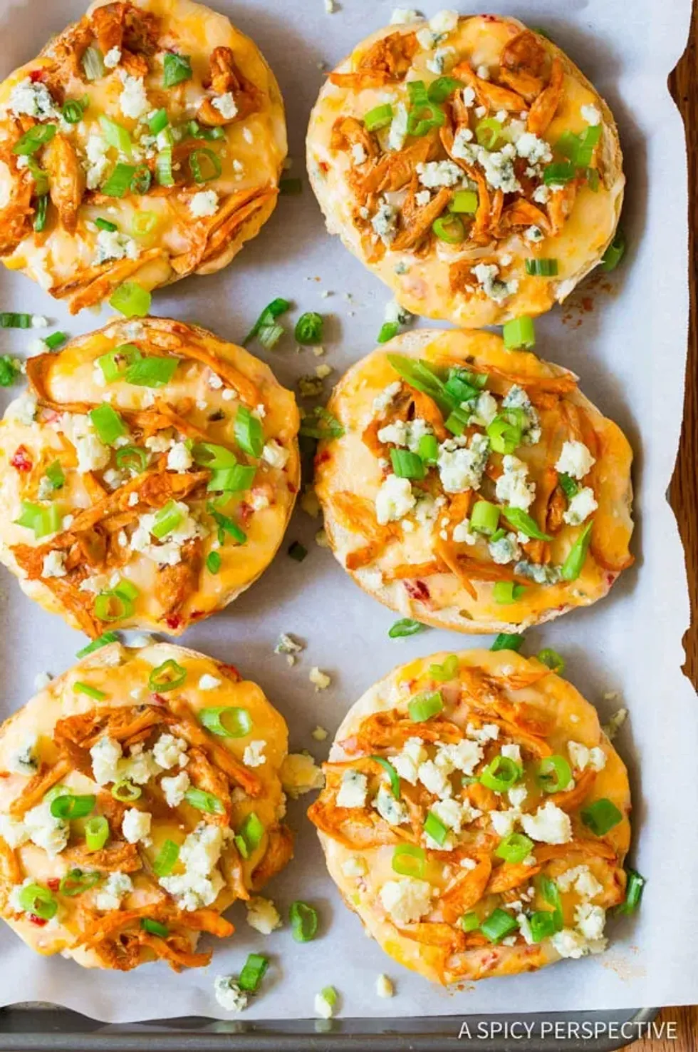 Buffalo chicken cheese pizza bagels are on a tray.