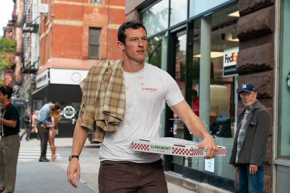 callum turner carrying a pizza