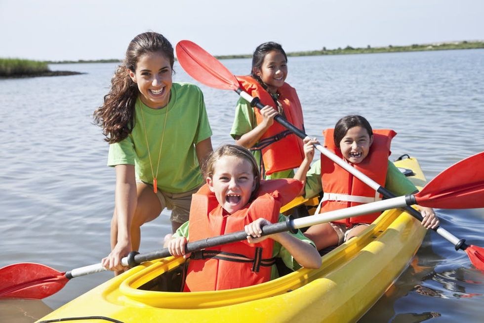 Camp counselor with campers in kayak
