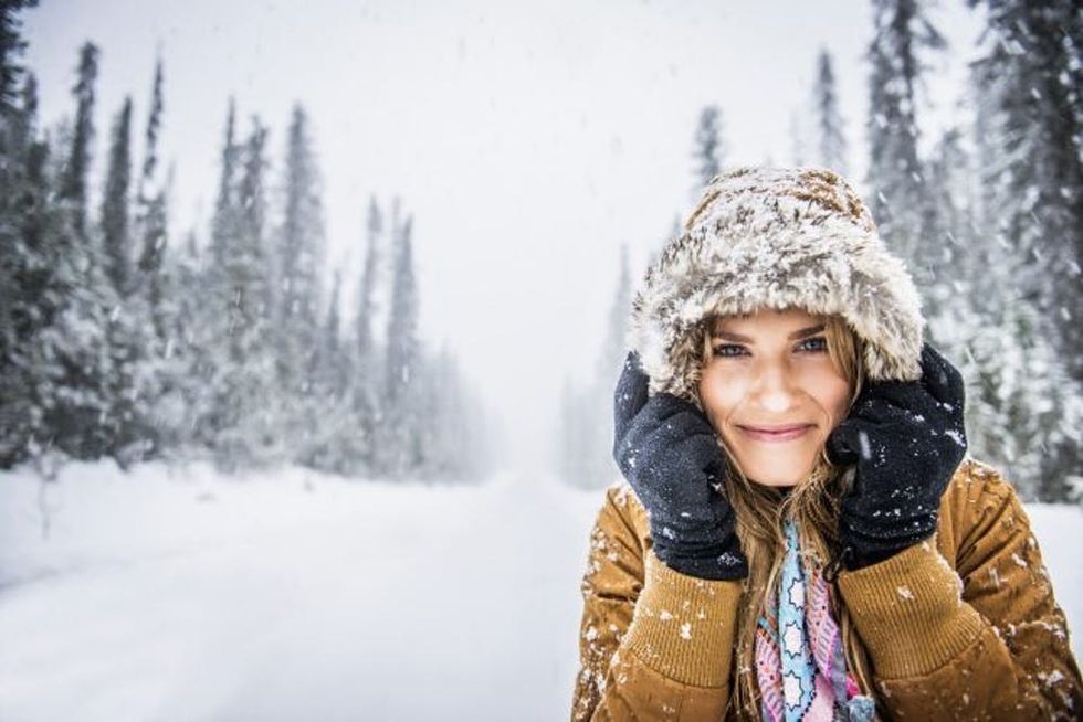 Caucasian woman wearing fur parka hood in snow