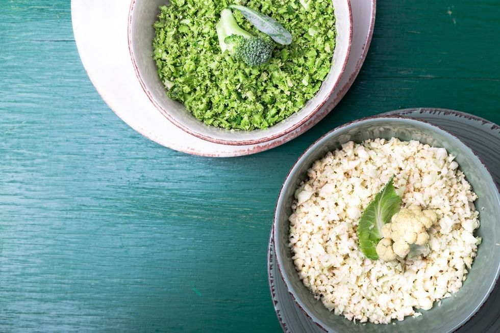 Cauliflower rice and broccoli rice in bowl on green background. Top view. Overhead. Copy space. Shredded.