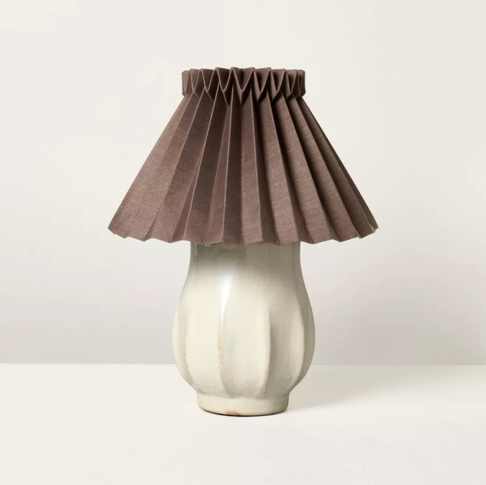 Ceramic lamp with a pleated brown shade on a plain background.