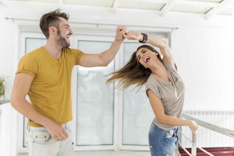 Cheerful couple having fun while dancing together.