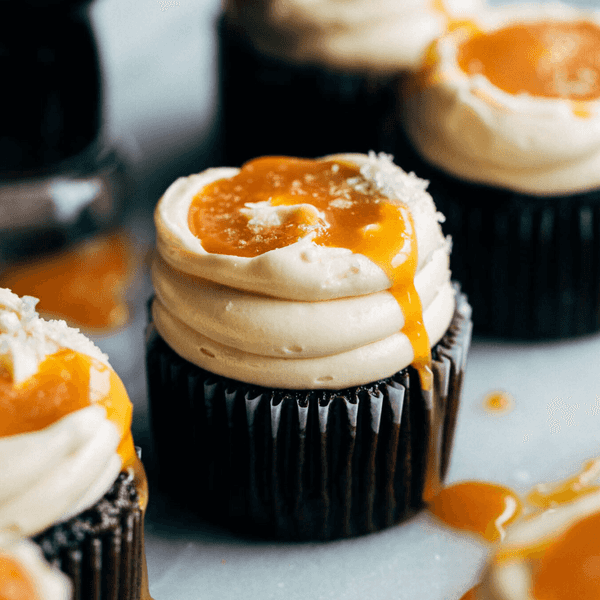 Chocolate cupcakes with creamy frosting and orange drizzle.