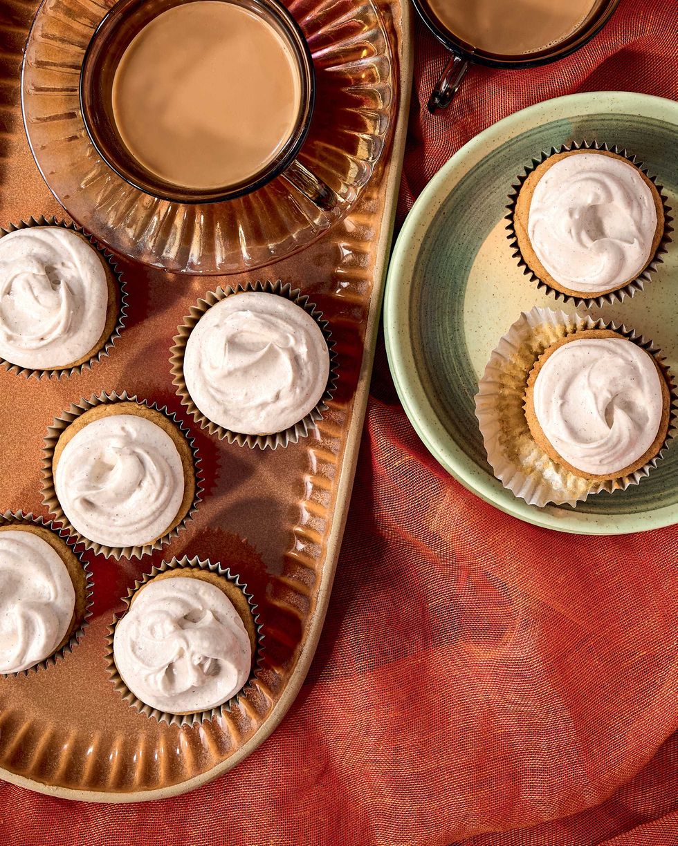 Cinnamon cupcakes with coffee served on a red cloth backdrop.