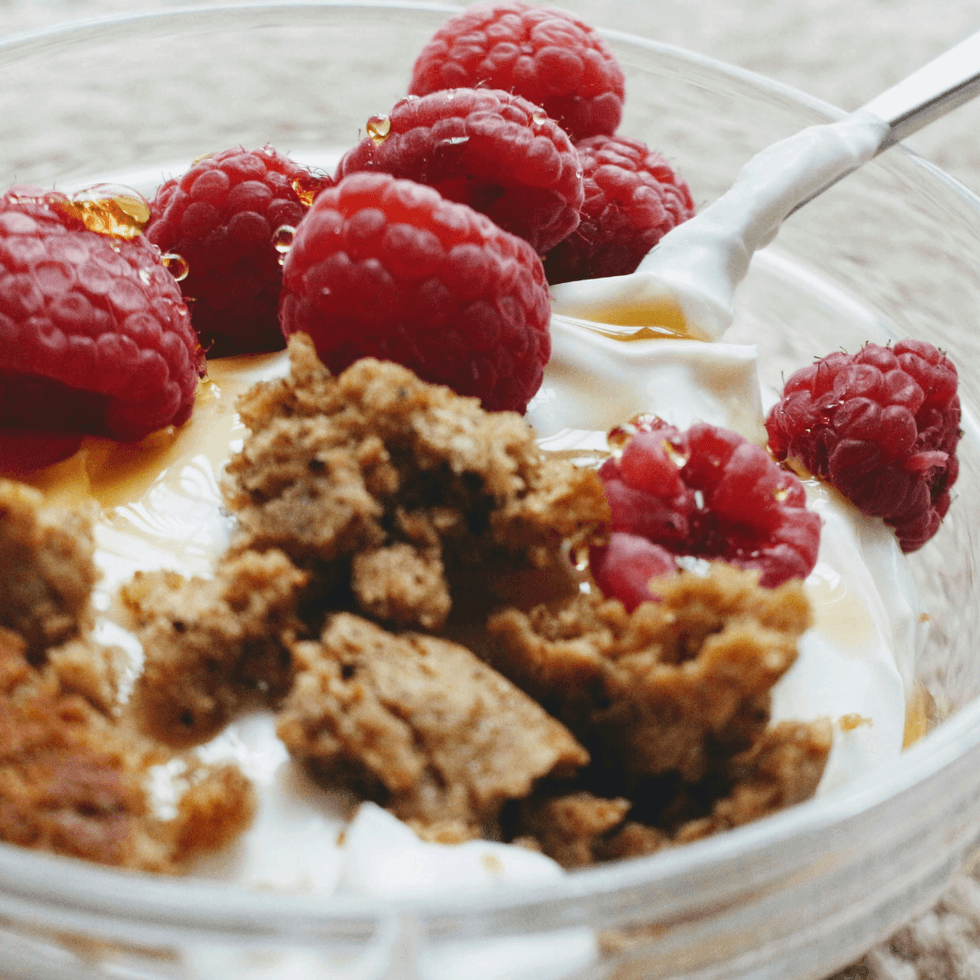 Close-up of a Greek yogurt bowl with granola and raspberries