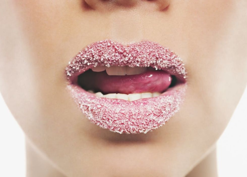 Close up of woman's lips covered in sugar.