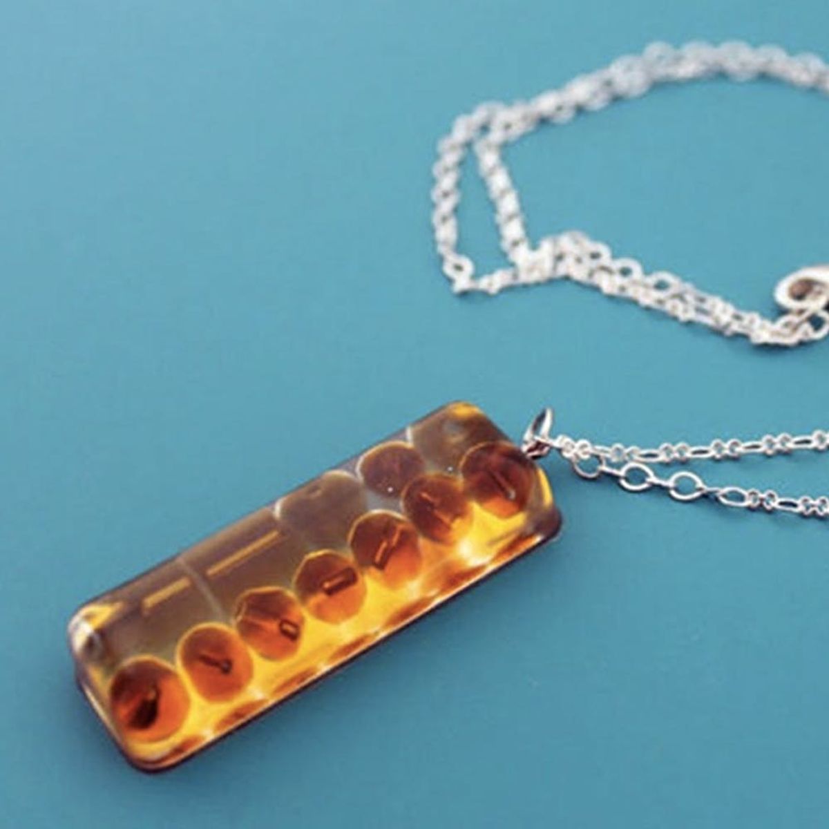 Close-up view of amber resin jewelry pendant on a silver chain