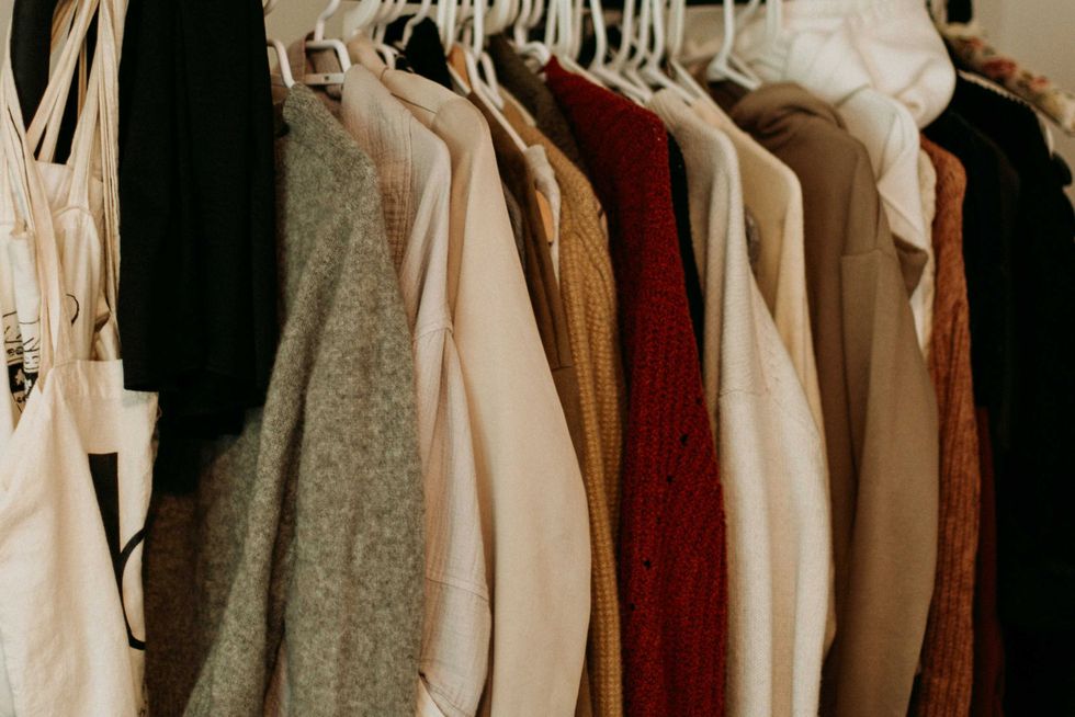 Clothes on hangers, various neutral tones, including beige, grey, and maroon.