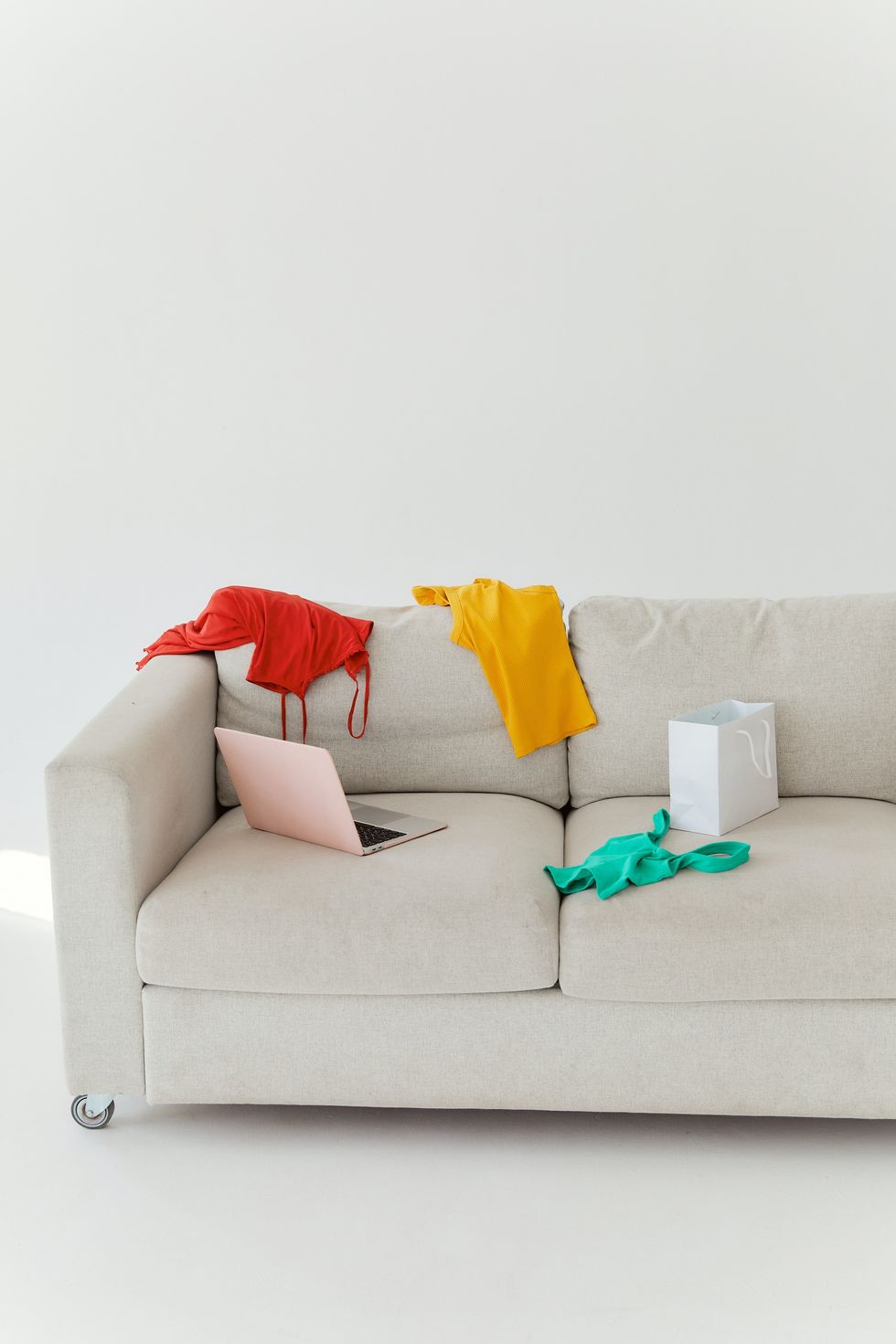 colorful clothes strewn on gray sofa