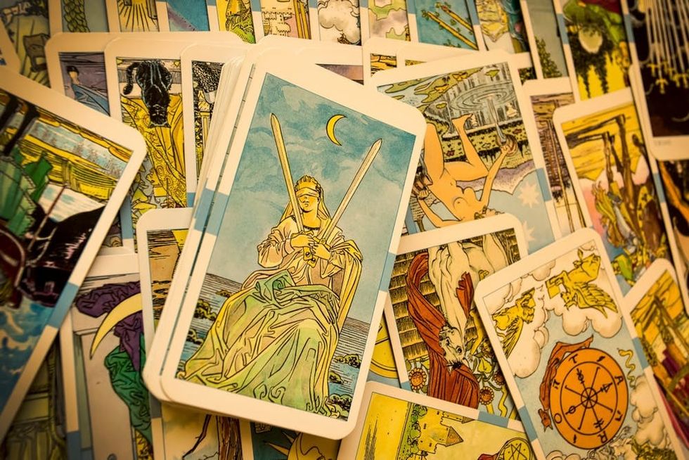 Colorful old tarot cards are arrayed on a table