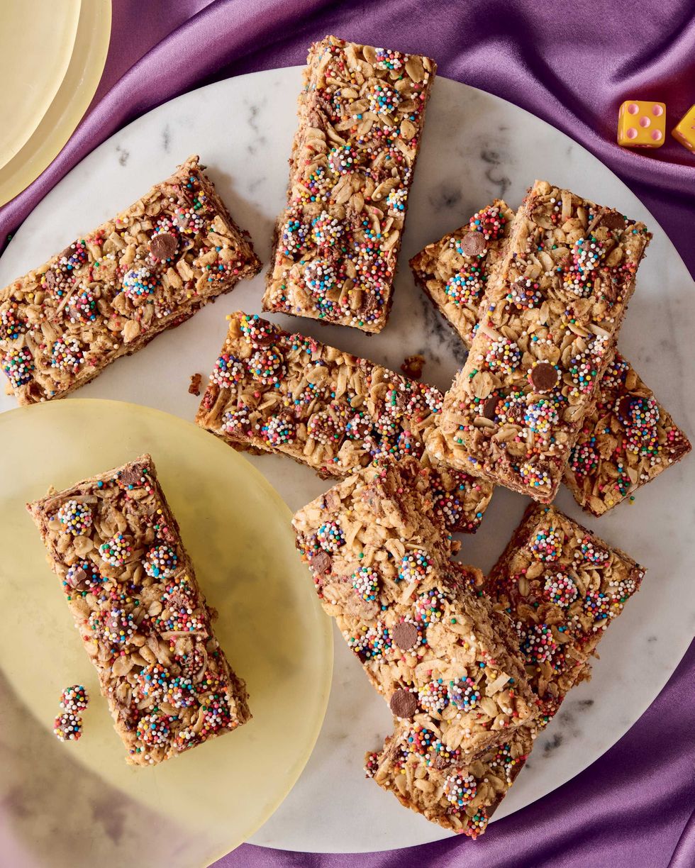 Colorful sprinkled cereal bars on marble and yellow plates.