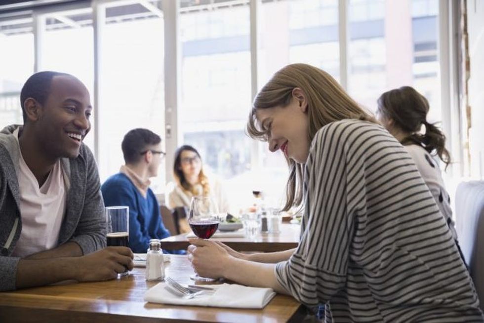 Couple drinking beer and wine at bistro table