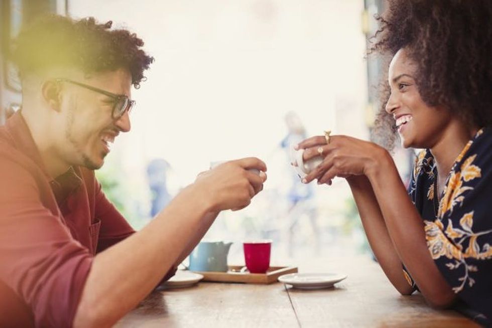 Couple drinking coffee face to face in cafe