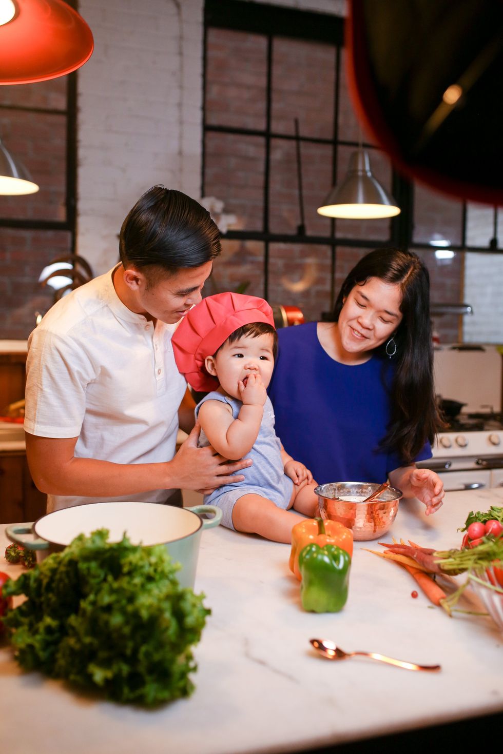 couple holding baby on kitchen counter