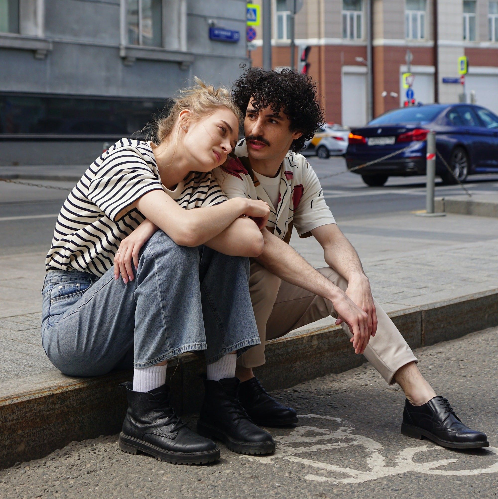 couple leaning on each other on a city street aries compatibility