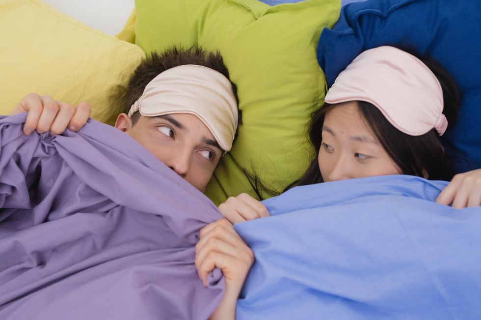 couple looking at each other in colorful sheets dreaming about an ex