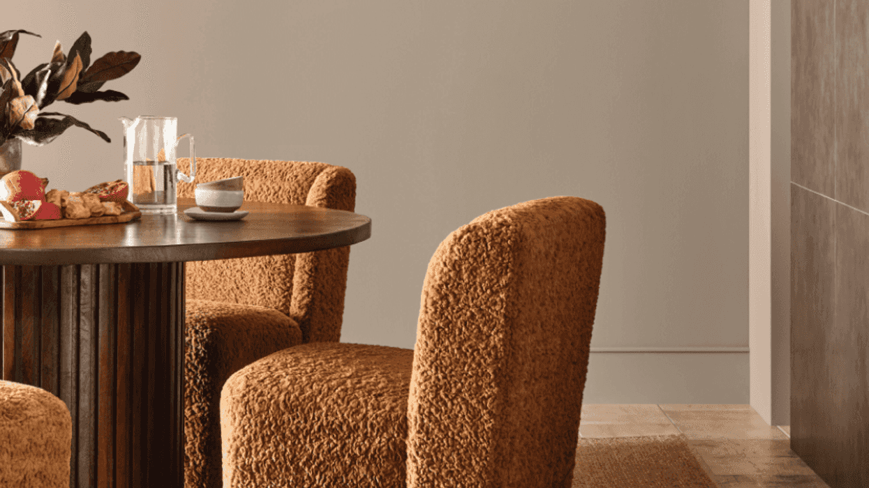 Cozy dining area with brown chairs, round table, and modern pendant light.