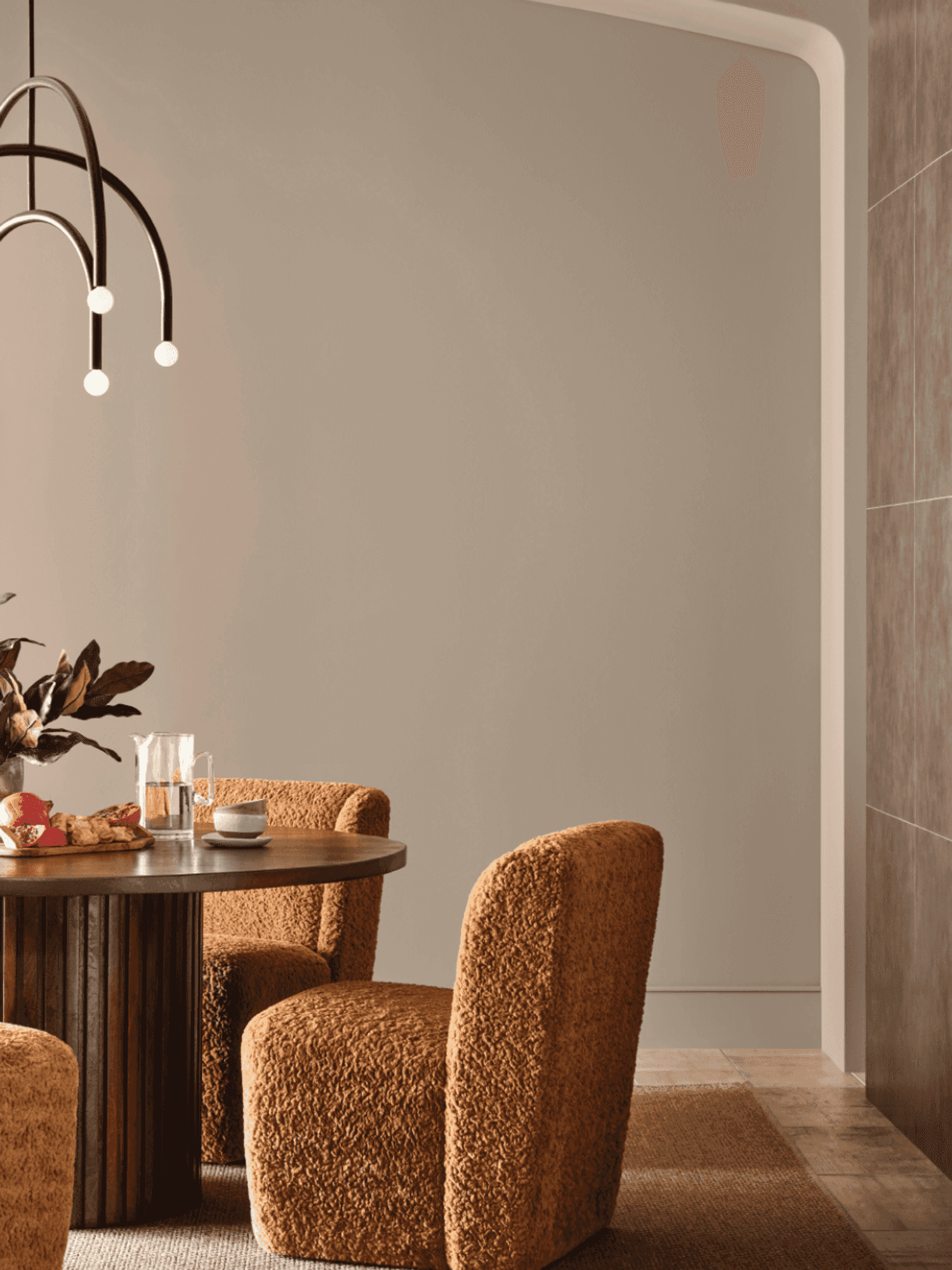 Cozy dining area with brown chairs, round table, and modern pendant light.