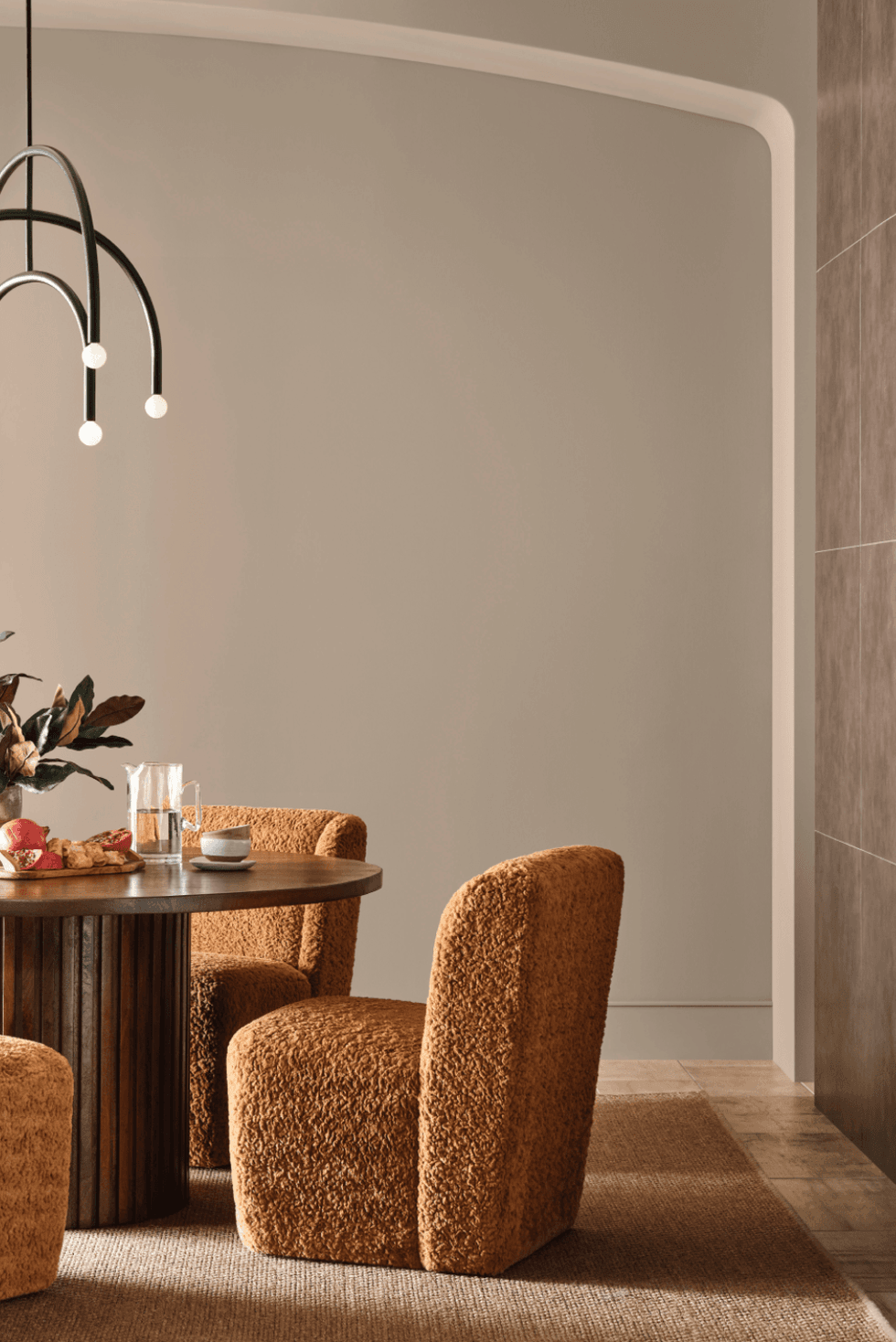 Cozy dining area with brown chairs, round table, and modern pendant light.