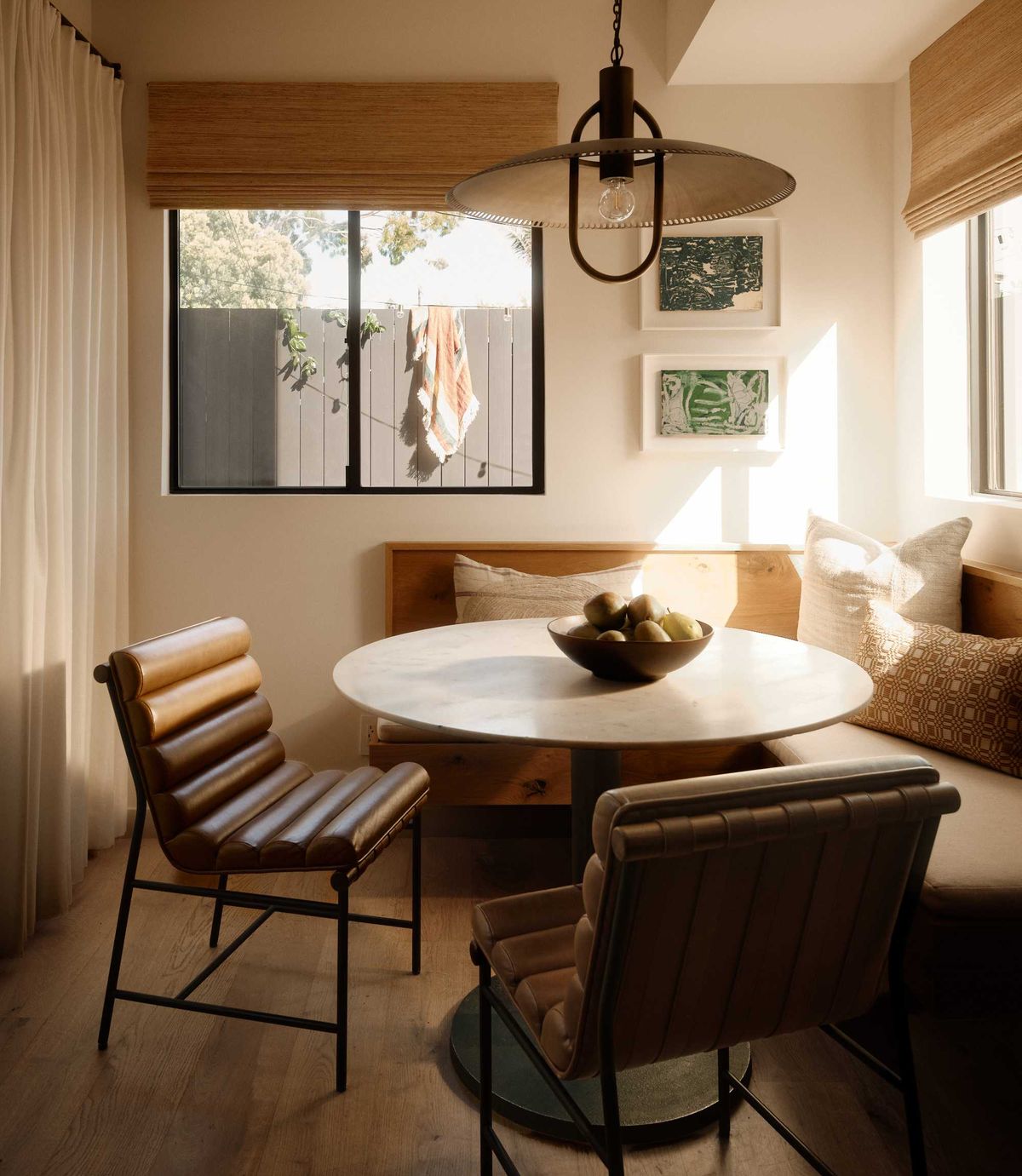 Cozy dining nook with a round table, leather chairs, and soft lighting.