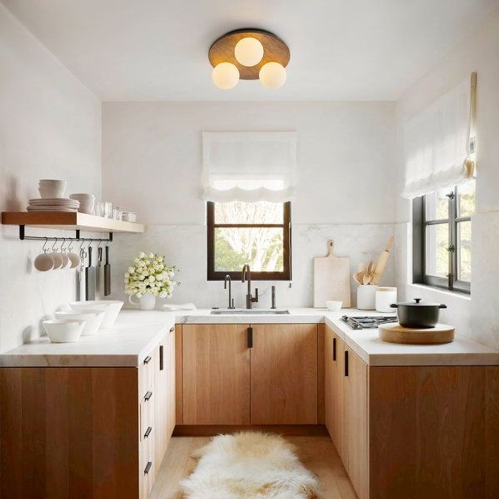 Cozy kitchen with wooden cabinets, white countertops, and soft lighting.