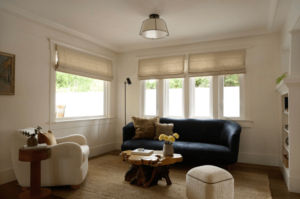 Cozy living room with a navy sofa, rustic wood table, and soft natural light.